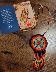 Beaded necklace bag from Mother Sierra with a postcard